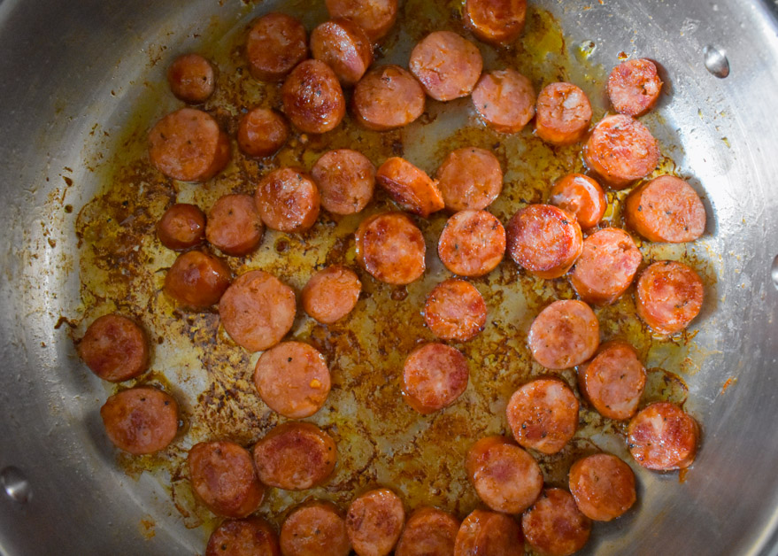 sliced sausage cooking in pan