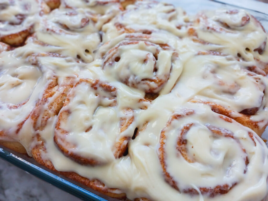 Pan of cinnamon rolls with cream cheese frosting on top